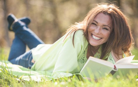 Woman reading book in field
