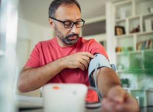 Photo of man preparing to check blood presure at home