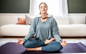 mom doing yoga with childs arms wrapped around her neck