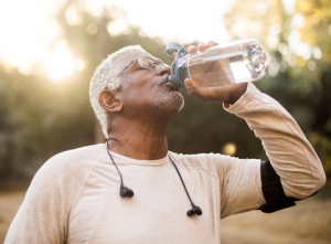 A senior African American Man enjoying refreshing water after a workout