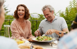 A pair of empty nester enjoy an al fresco lunch with friends.
