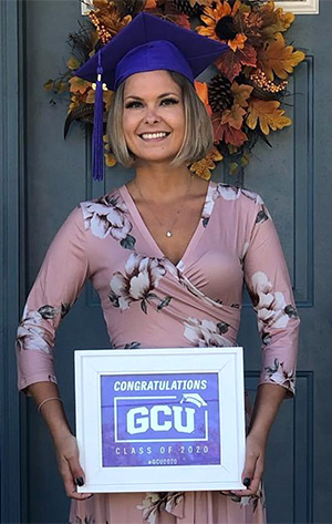 Erika posa con su diploma de la GCU