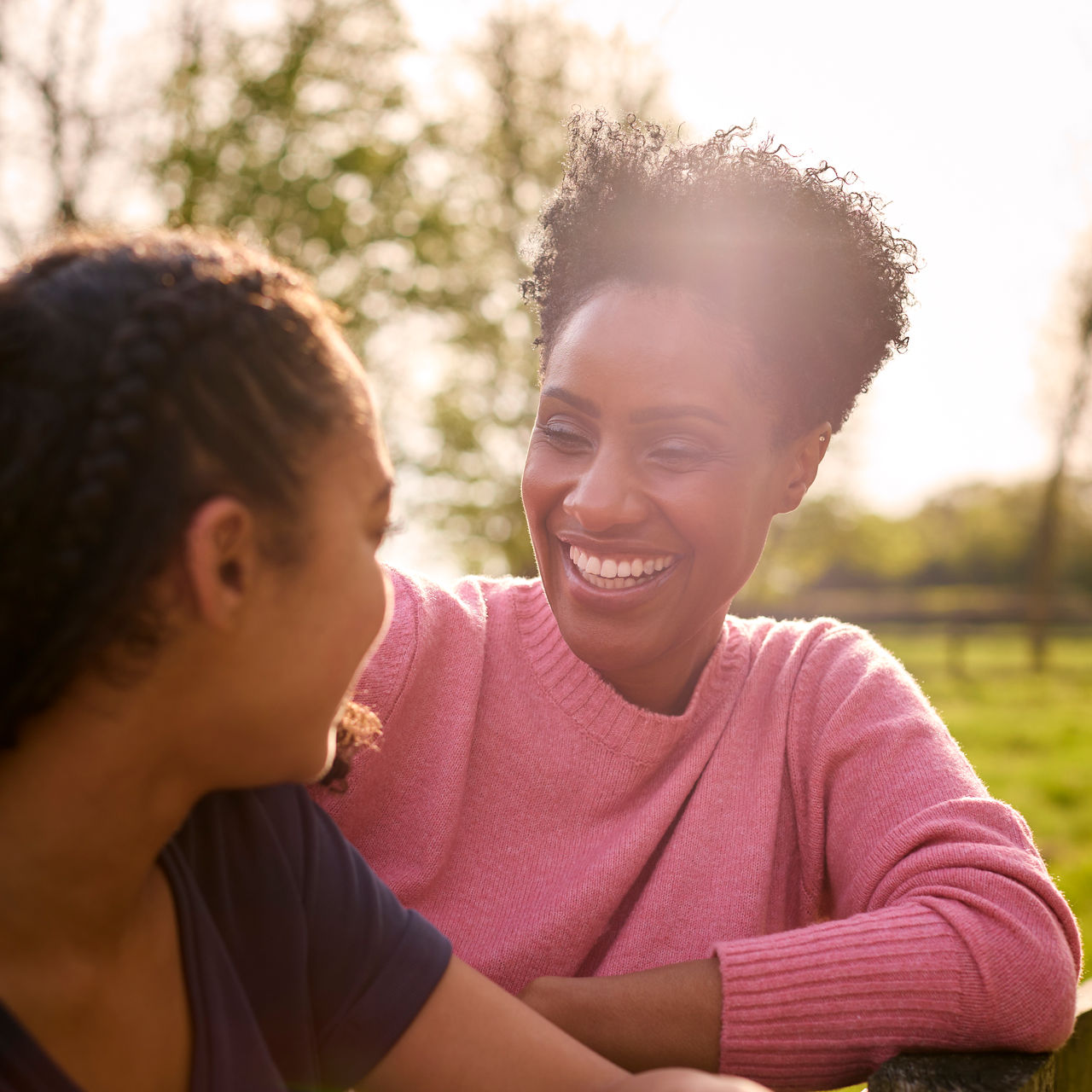 A mother and teen daughter share a warm smile.