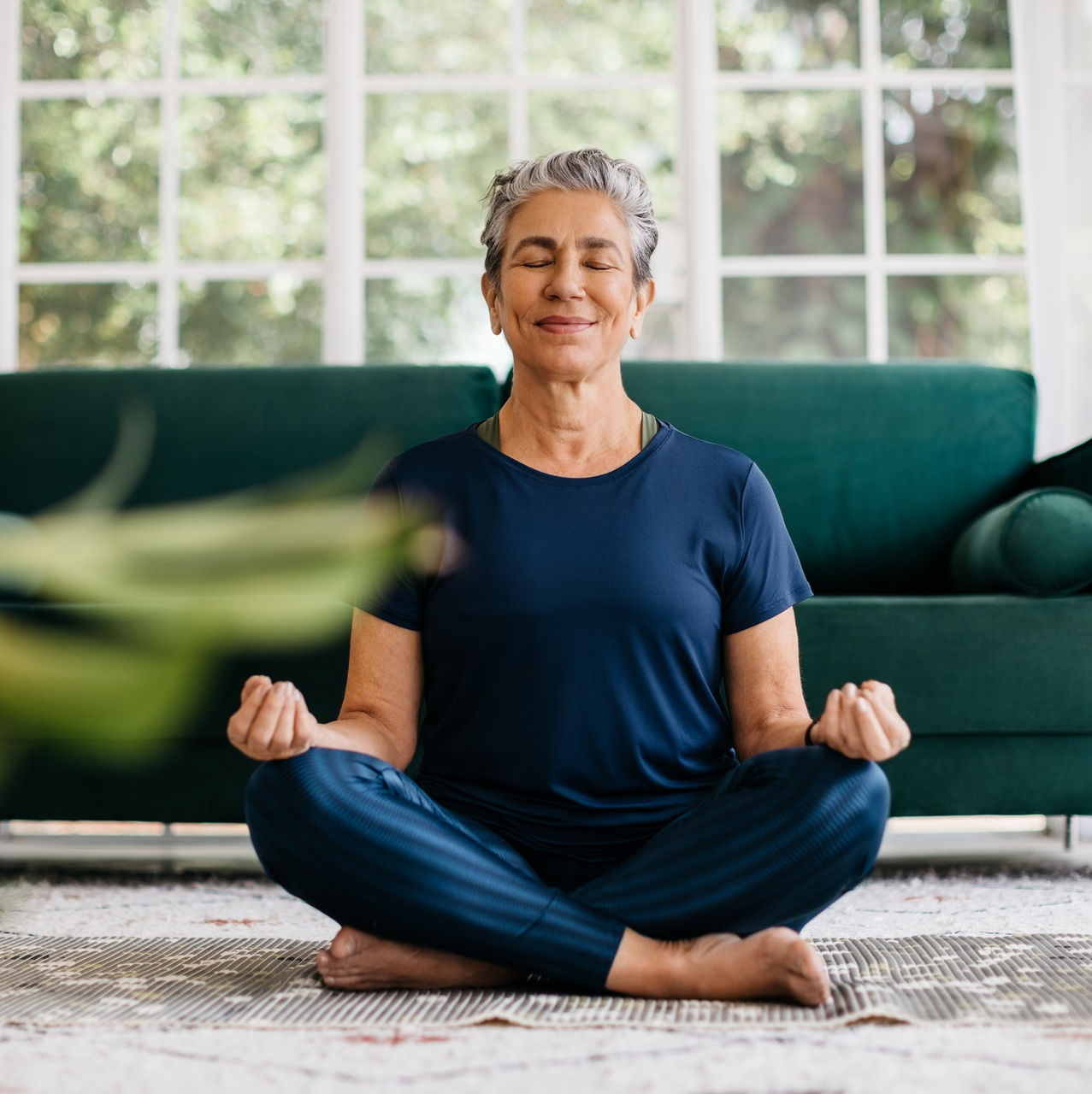 A mature woman smiles peacefully.