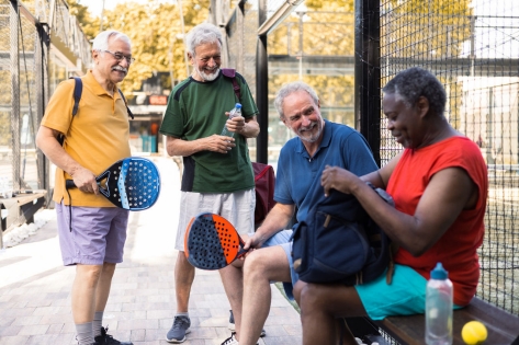 Happy senior friends meeting to play paddle ball.