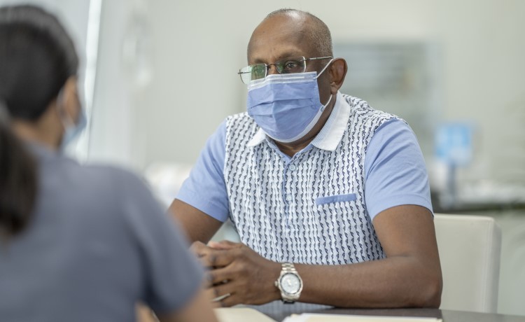 doctor shows cancer resources to patient on tablet