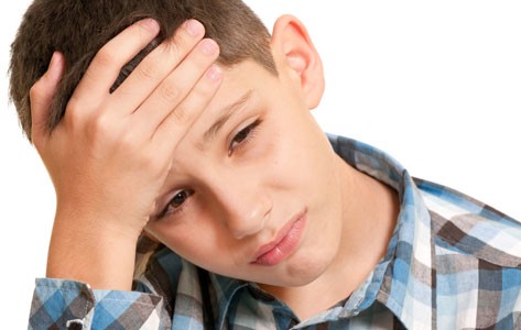 Boy with headache holds head