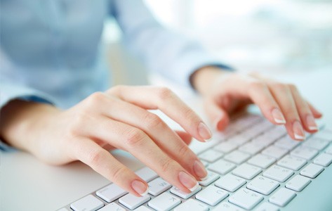 A woman typing on a keyboard.