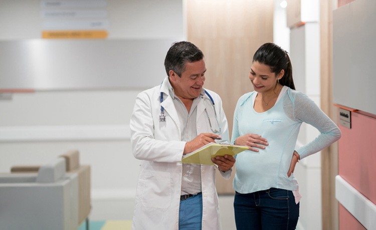 Expectant mother tours maternity center with OBGYN