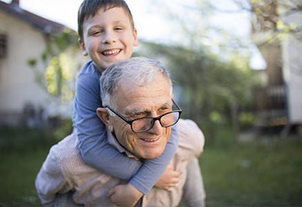 A grandfather gives a piggy-back ride to his grandson.