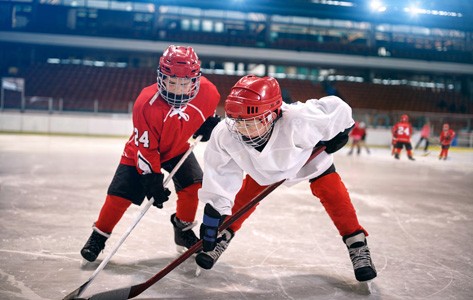 two kids fight for puck in youth ice hockey game