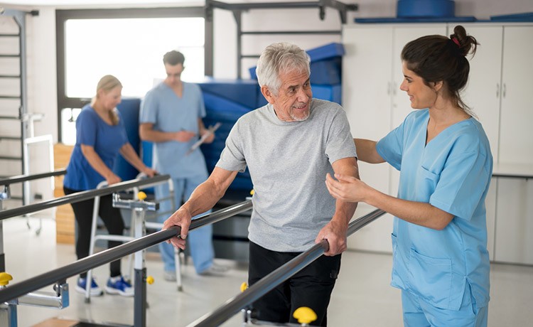 Man walks with handrails during physical therapy