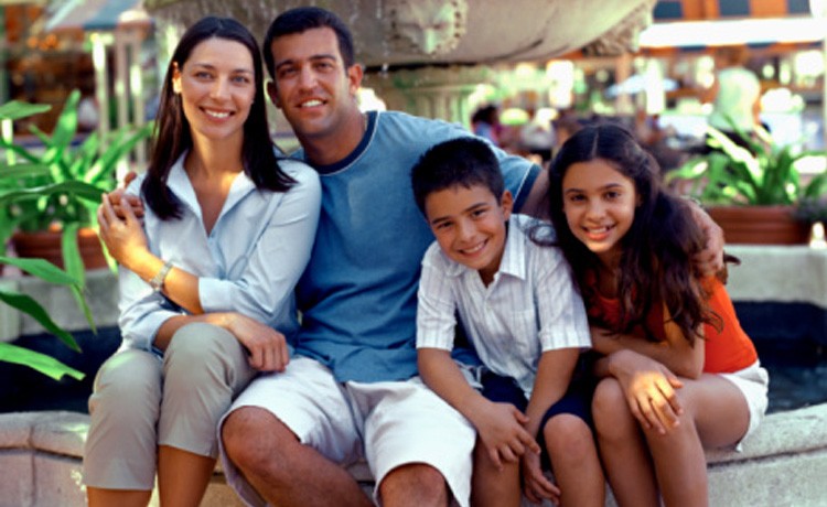 Family sitting by fountain