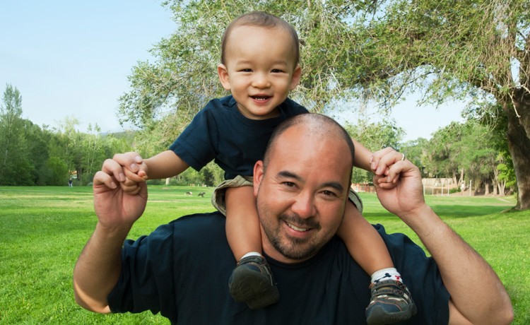 Man holds child on shoulders