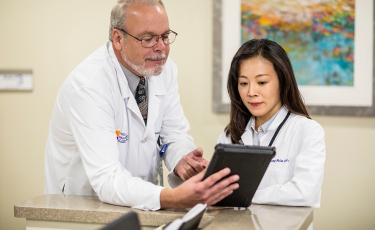 Two Doctors looking at clipboard