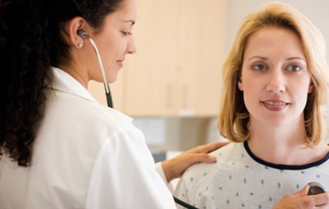 nurse examining patient's heart rhythm