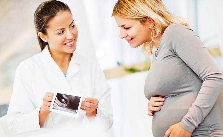 Doctor shows fetal ultrasound to mother