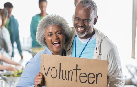 Couple holiding volunteer sign