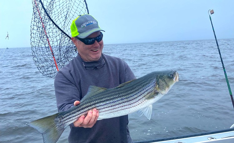 Jim N. admires an epic fishing catch after recovering from bilateral knee surgery.