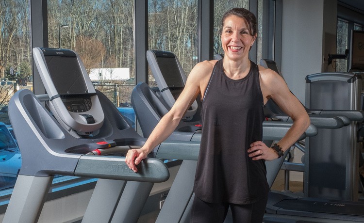 Adrianne stands on a treadmill after orthopedic rehab.