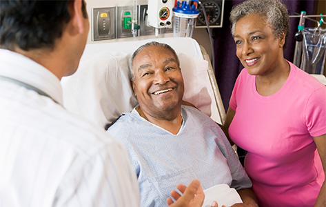 A patient and his wife speak with a doctor.