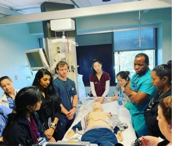 Residents next to a medical dummy